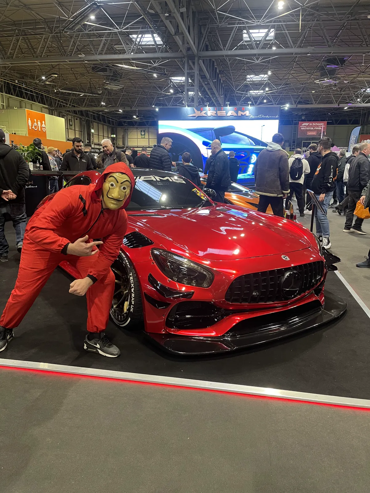 The red widebody AMG GT on a show stand with a Money Heist themed costume