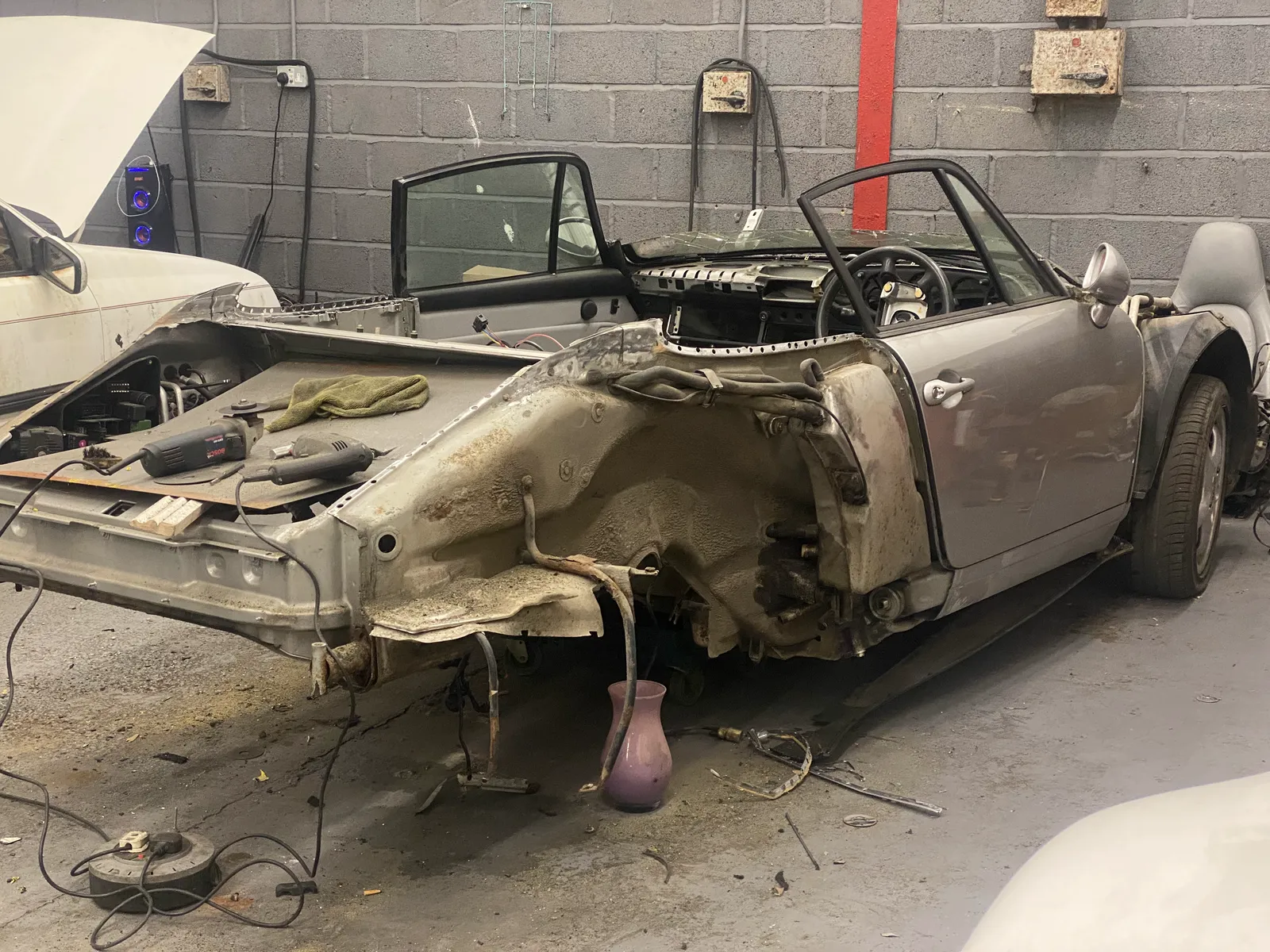 The Porsche 911 stripped to a bare, corroded shell before restoration