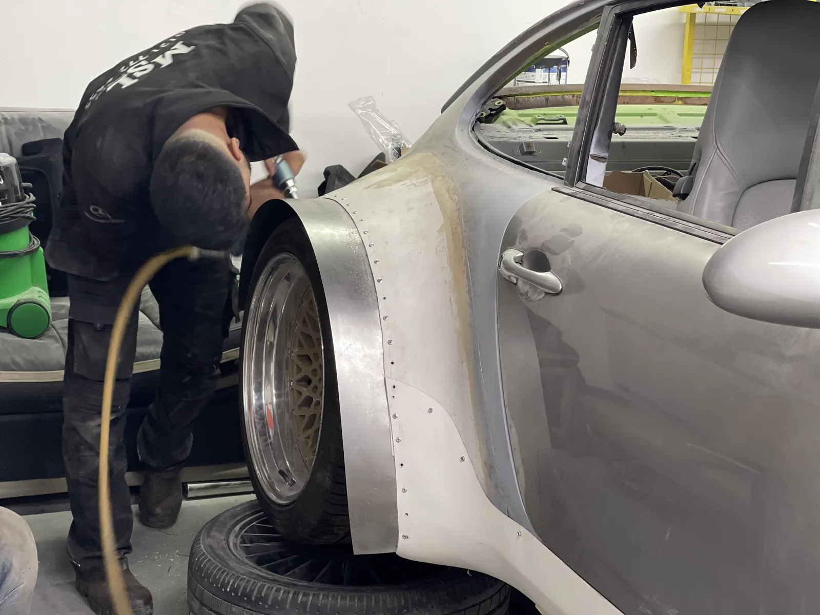 An MSL Customs technician working a fabricated arch on the Porsche 911