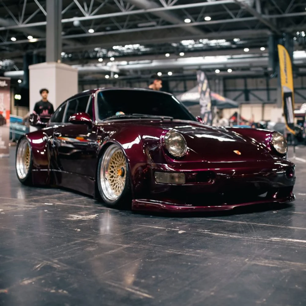 The finished Porsche 911 in deep metallic paint at a show